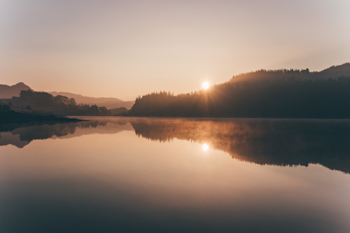 Lac au crépuscule avec reflets, symbole de contemplation et de passage intérieur