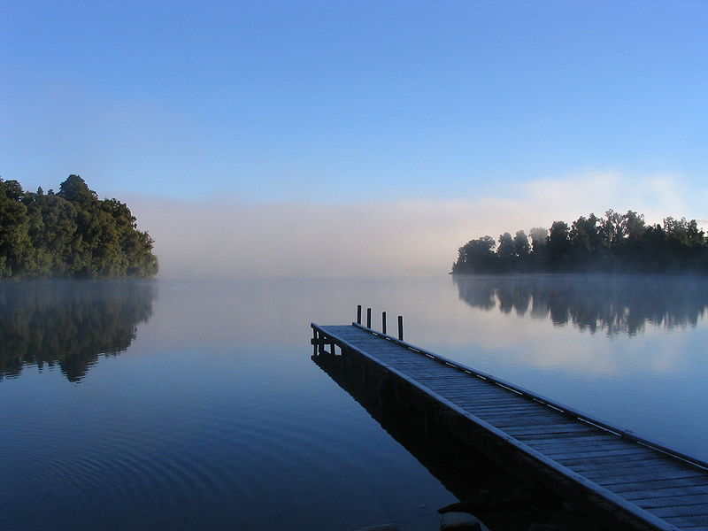 Ponton s'élançant vers un lac brumeux au lever du jour, symbole de transition intérieure